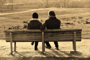 two people on a bench talking