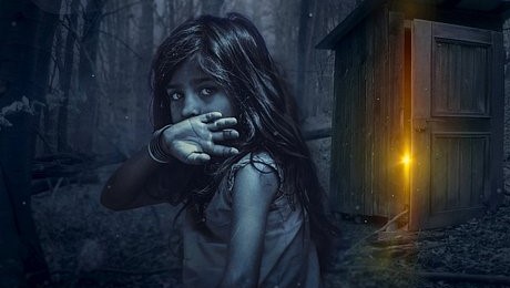 young girl in dark forest with shed behind emitting a golden light