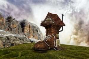 A house sized boot in a green field with cliffs behind