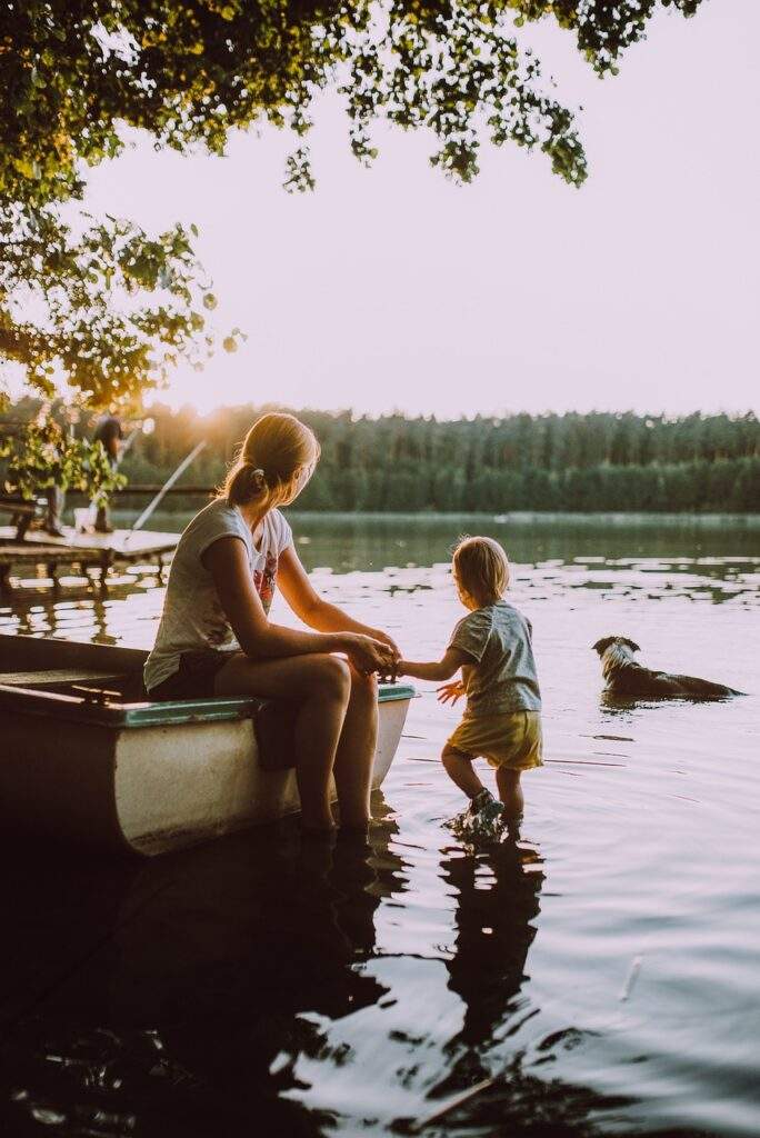 woman with child and dog in a river