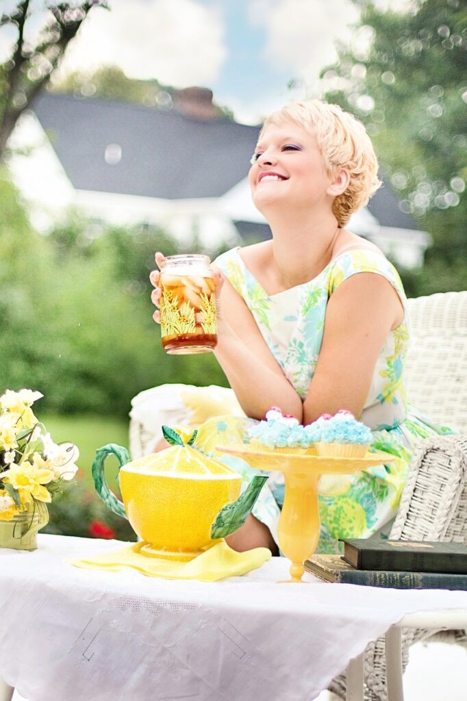 woman laughing holding a glass of tea