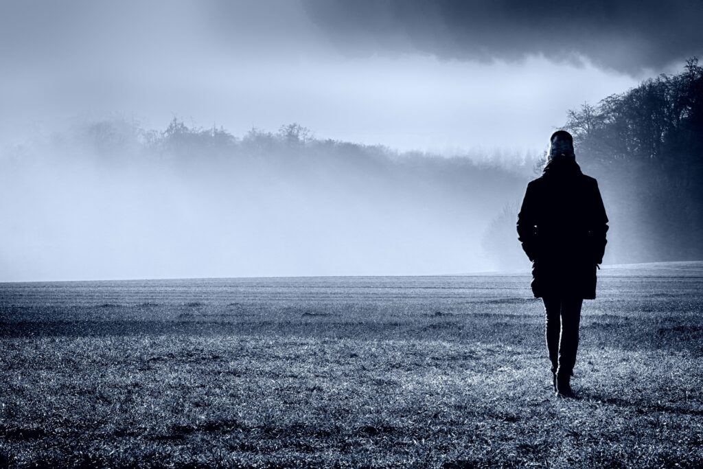 woman walking in a foggy field
