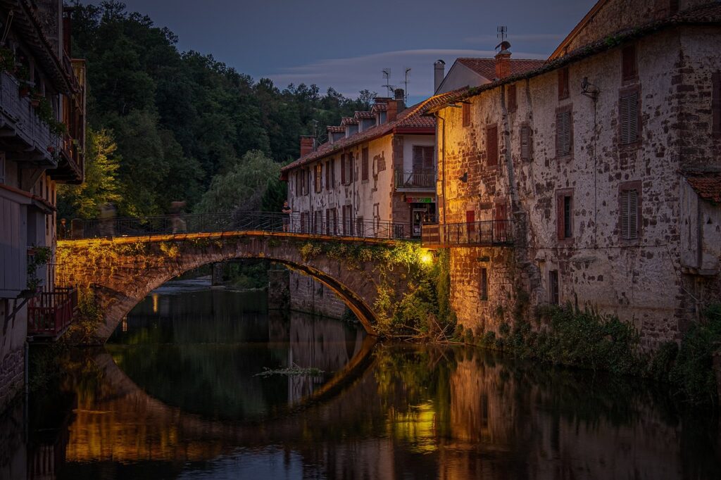 Nothing breaks the serenity of the water - a bridge over a river at sunset